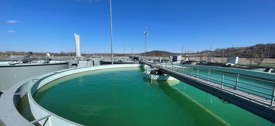 A water tank filled with green-tinted water and a bright clear sky