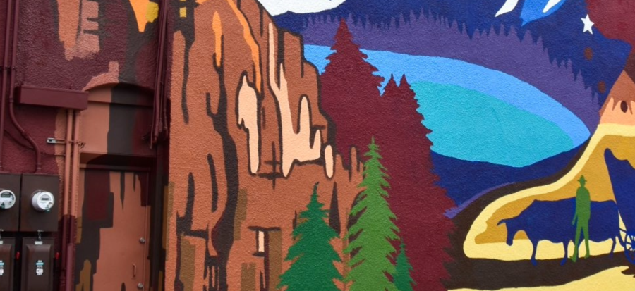 Image of a part of the three trails mural showing a painting of wagon, trail, lake, and trees.