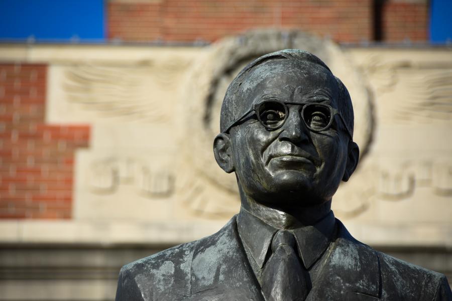 President Truman statue located at Historic Truman Courthouse with brick building behind him.