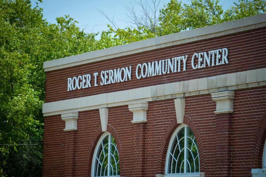 Roger T Sermon Community Center building with green trees in background and arched windows in foreground.