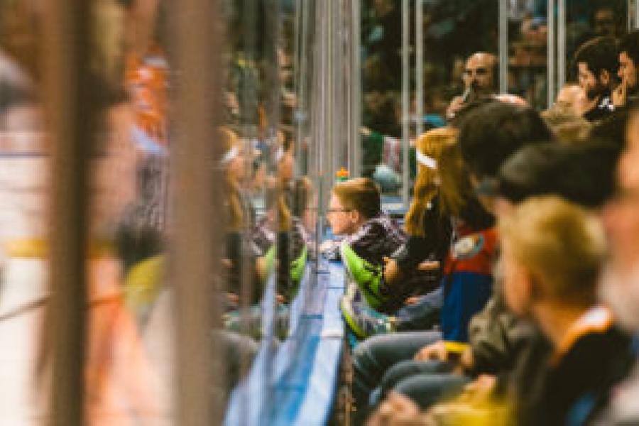 Fans watch a KC Mavericks game through the hockey glass