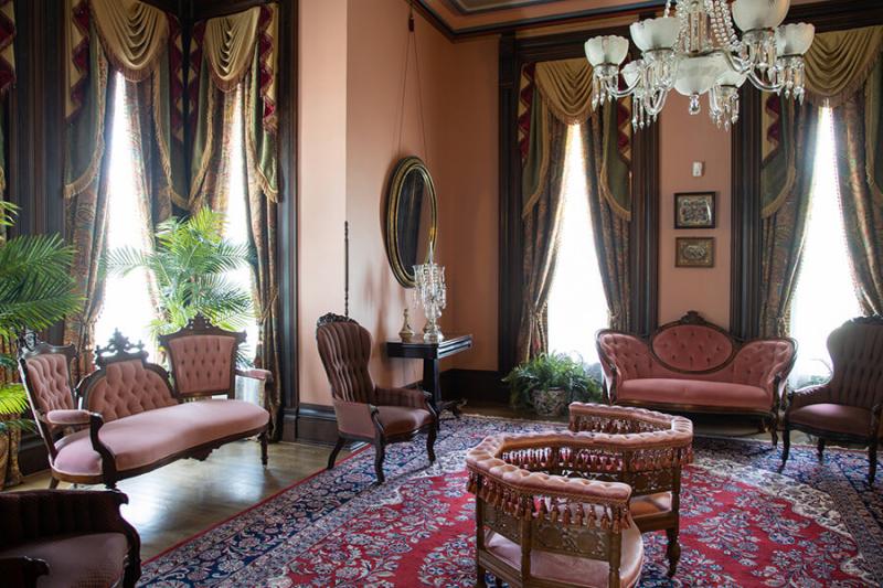 Ladies' parlor room in the Vaile Mansion with pinkish mauve love seats and chairs. 