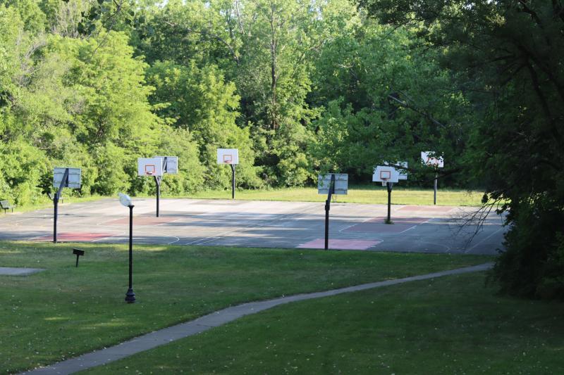 An image of four basketball courts with trees in the background at Bundschu Park.