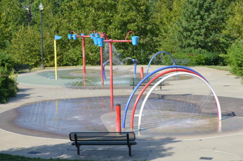 An image of different splash pad features spraying out water on a concrete area at McCoy Park.