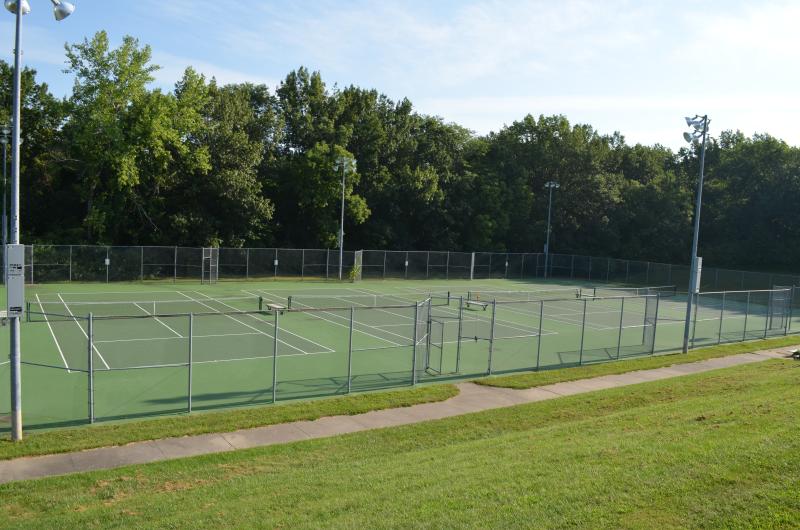 An image of four tennis courts with trees in the background at Santa Fe Park.