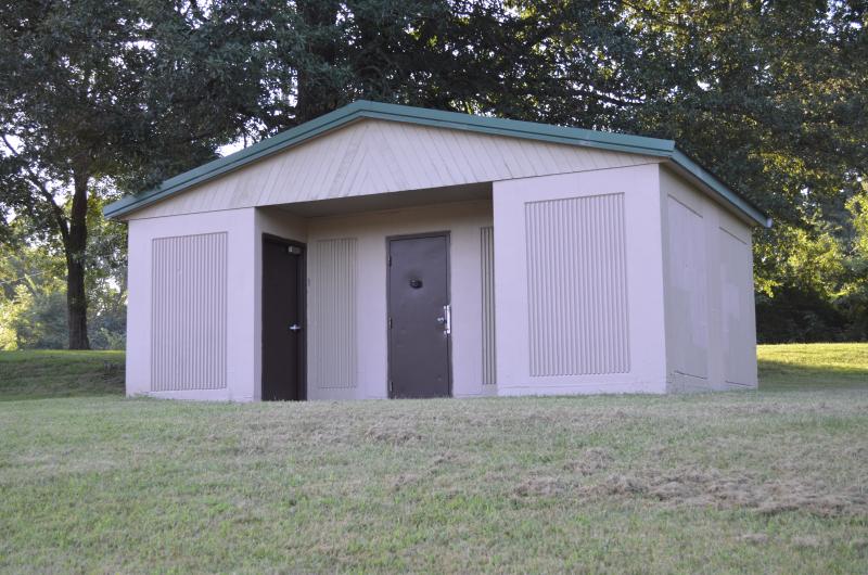 An image of the men's and women's restroom structure up on a hillside at Van Hook Park.