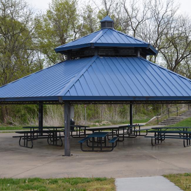 A picture of the Mill Creek Park pavilion with picnic tables under the structure.