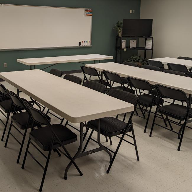 A picture of rectangle tables and folding chairs set up in the Palmer Center Park Place Meeting Room 