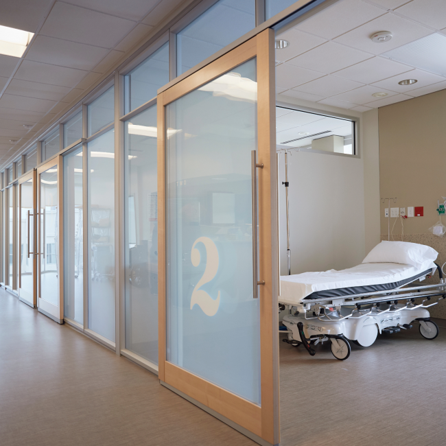 Image of an empty hall in a hospital with a room on the right side
