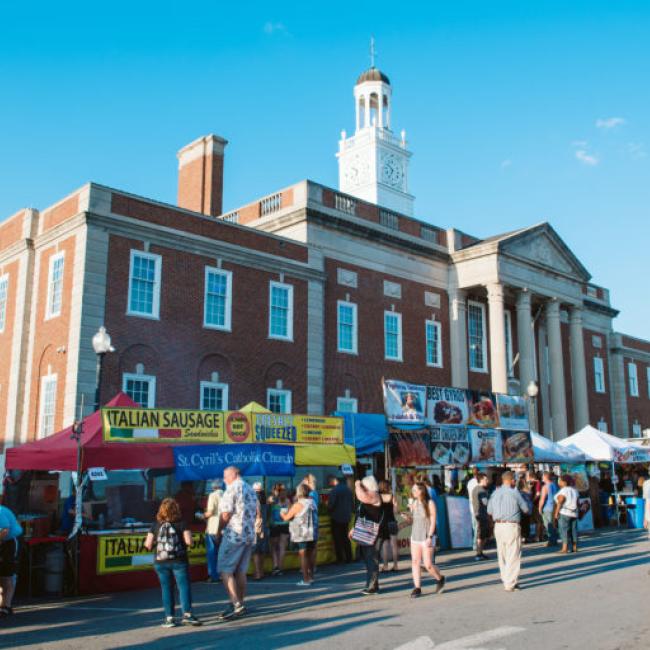 The historic Truman Courthouse on a sunny day with vendors in the foreground during the Santa Caligon festival.